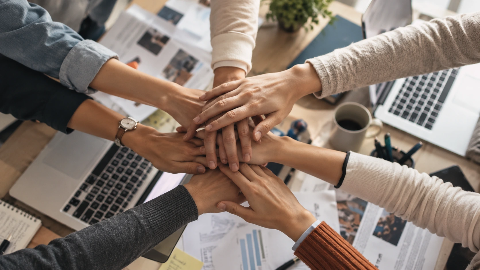 People bringing their hands together over a table